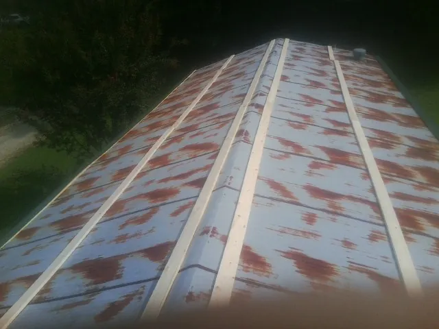 Rusted metal roof panels with new wood purlins before replacement — Storm Damage Roof Repair in Candia by Roofing Brothers